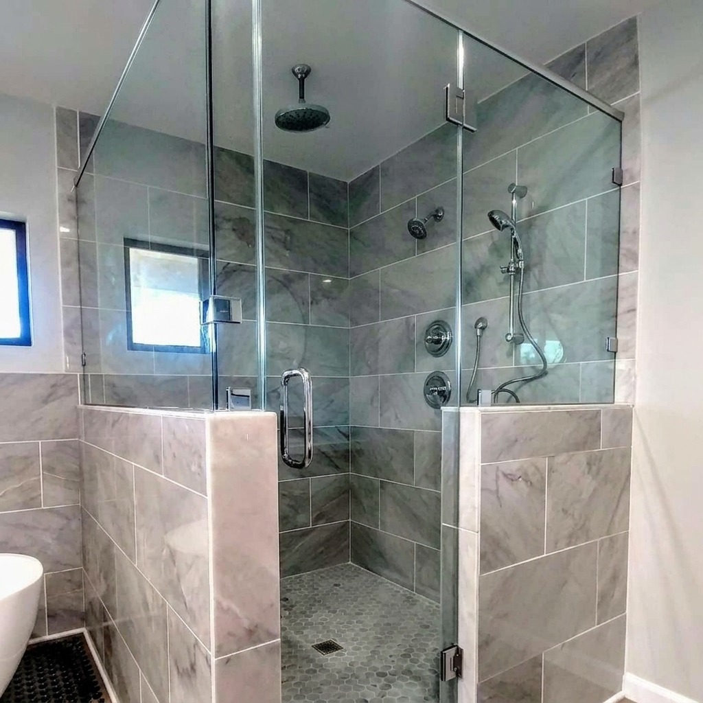 Frameless 90-degree shower enclosure with marble tile installed by Shower Doors of Austin
