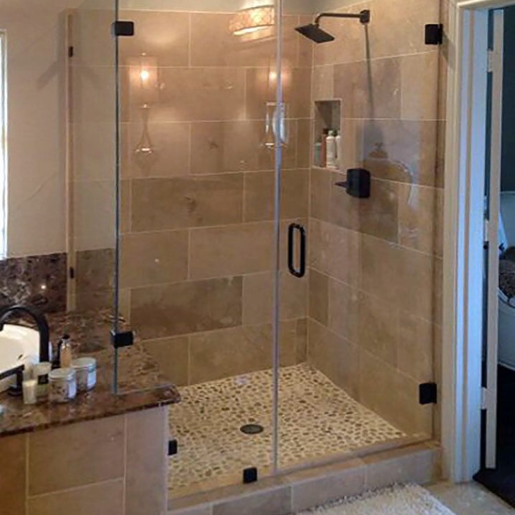 Frameless 90-degree glass shower enclosure with travertine tile walls