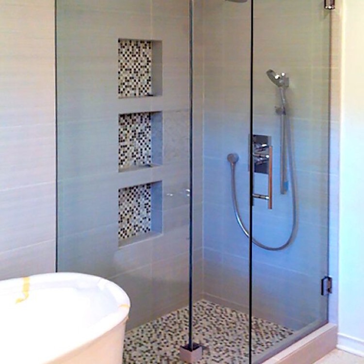 Frameless glass shower enclosure with three recessed tile niches