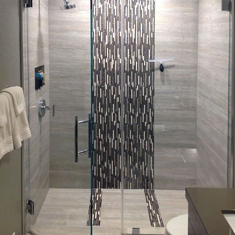 Frameless inline glass shower door with marble-look tile walls