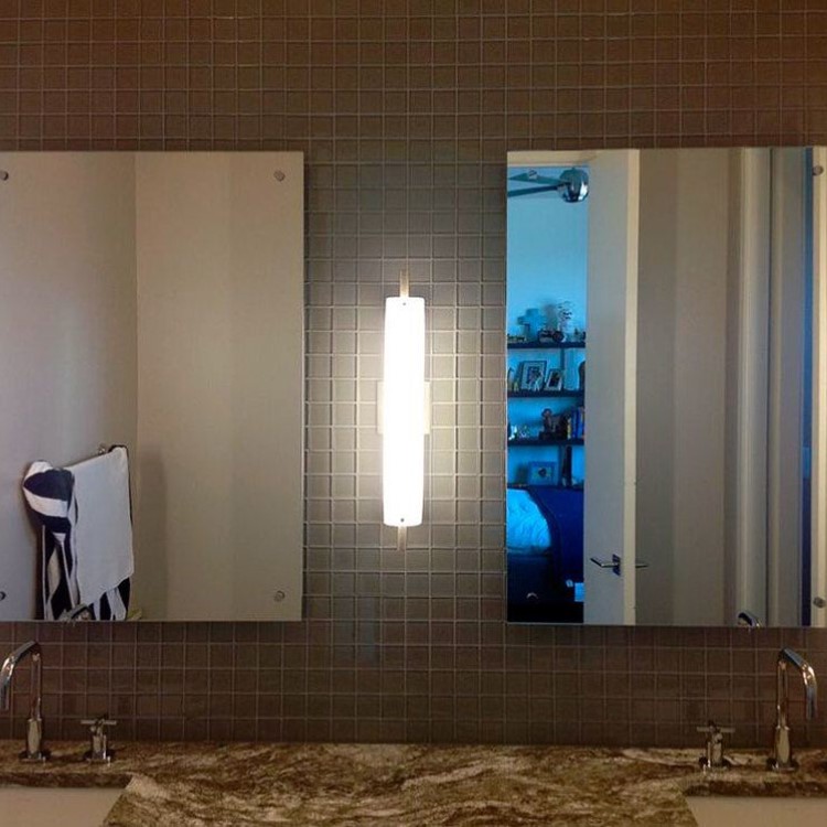 Standoff-mounted custom mirror above a granite vanity top