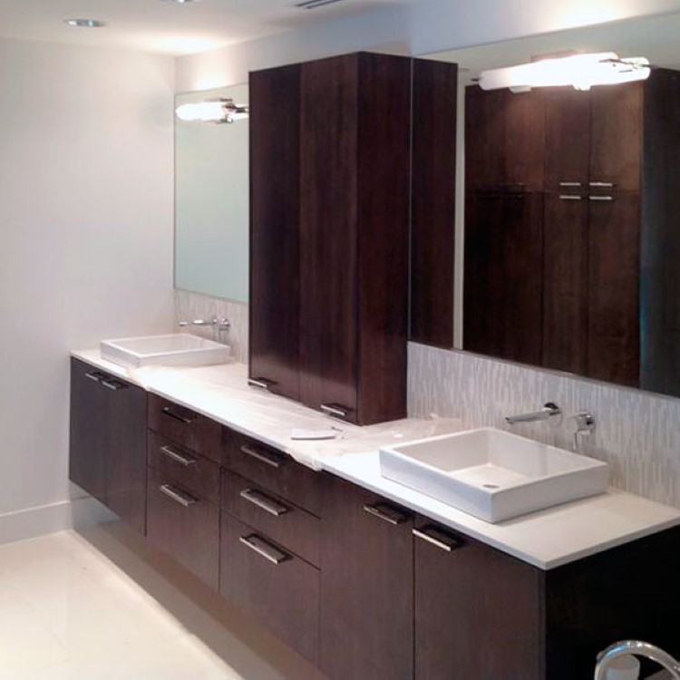 Unframed custom bathroom mirror above a dark wood double vanity