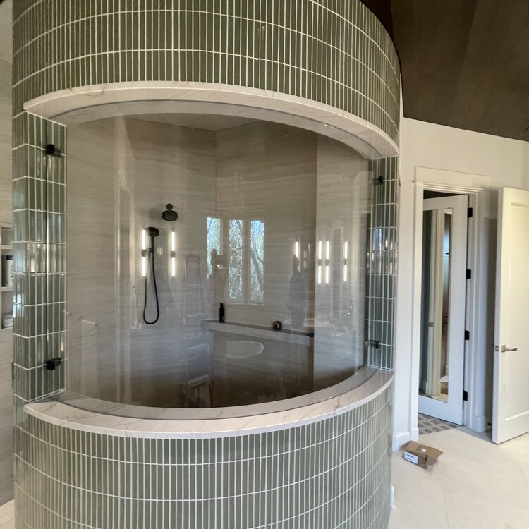 Curved Frameless Shower Enclosure Curved frameless glass shower enclosure with stacked tile walls
