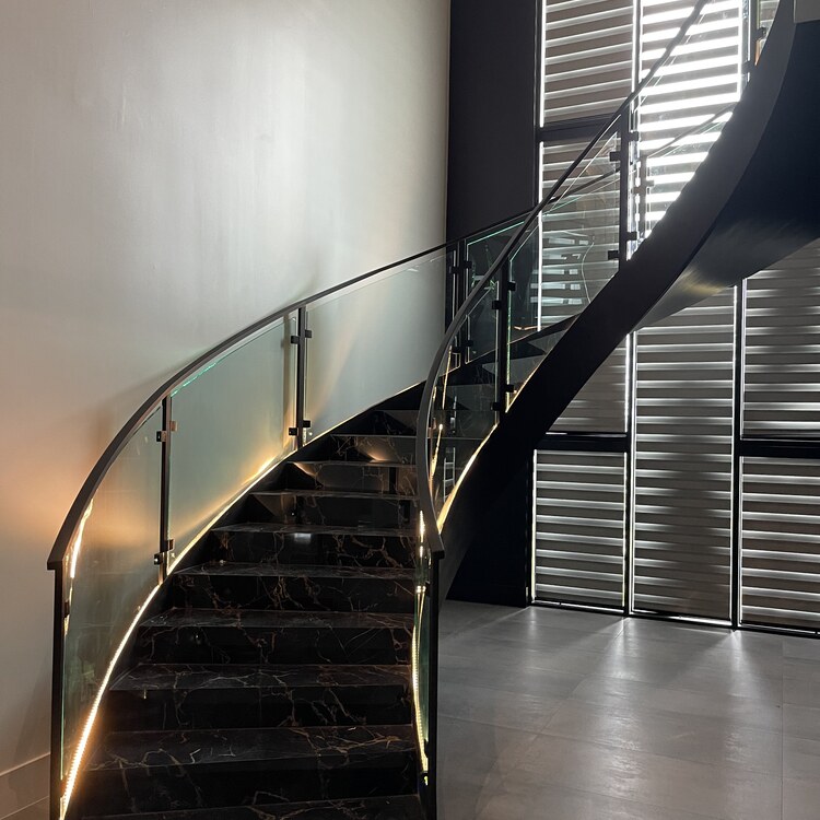 Curved glass railing following a spiral staircase