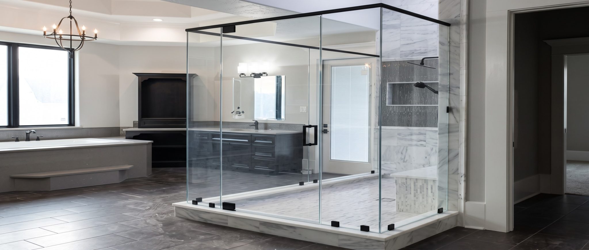 Freestanding frameless 90 degree shower enclosure with a black header frame