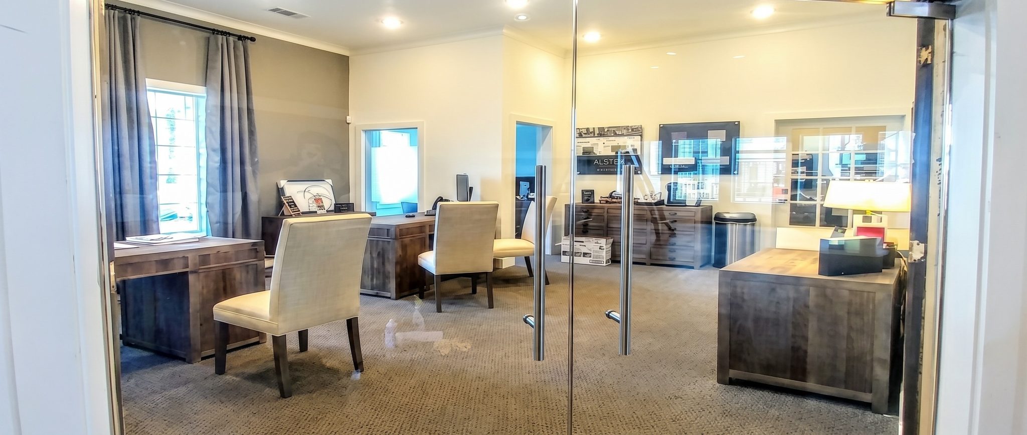 Frameless glass double doors with ladder pulls at an office entry