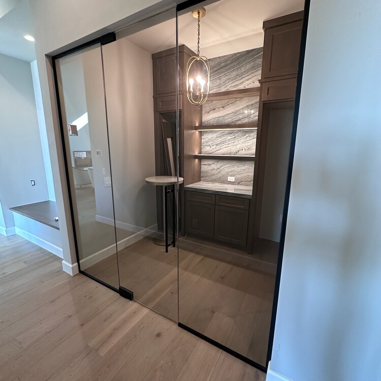 Glass Wine Room with a Patch Hinge Door Glass enclosed wine room with a frameless patch hinge door
