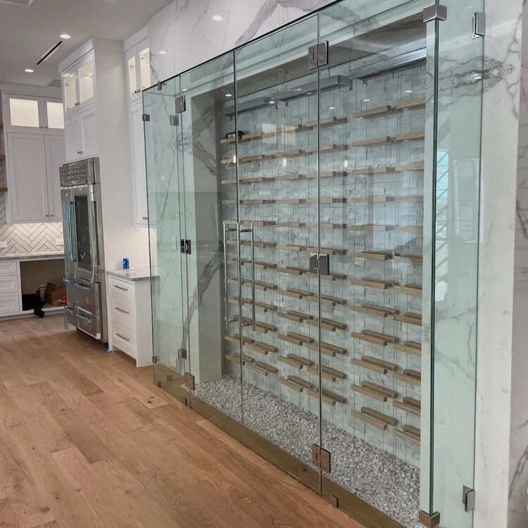 Floor to ceiling glass wine wall built beside a kitchen