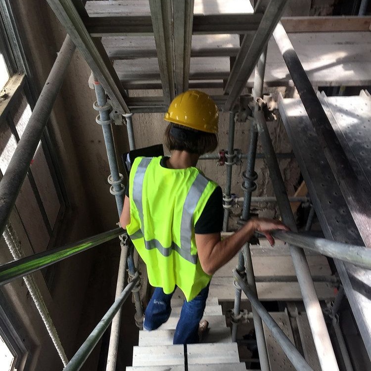 Worker on scaffolding inside a historic building during renovation