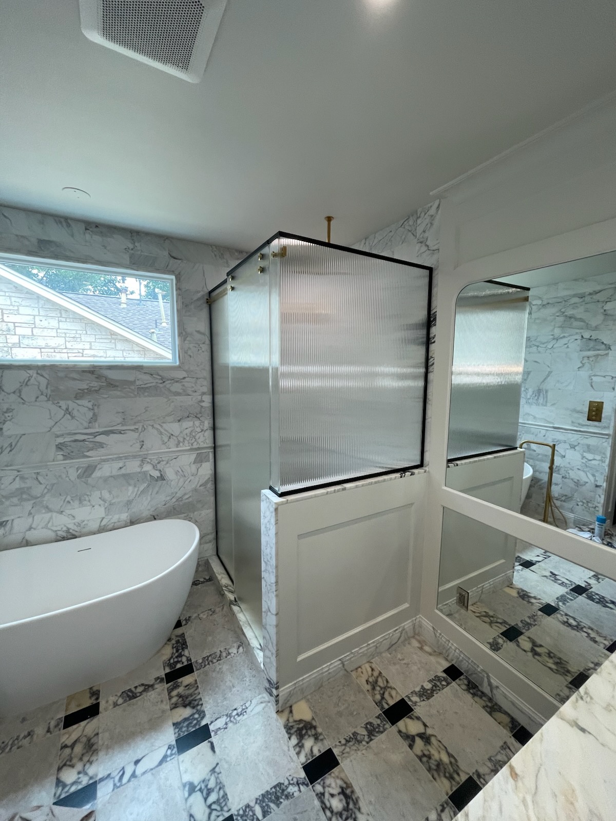 Reeded glass Serenity slider hardware detail on a 90-degree shower enclosure in Austin, TX