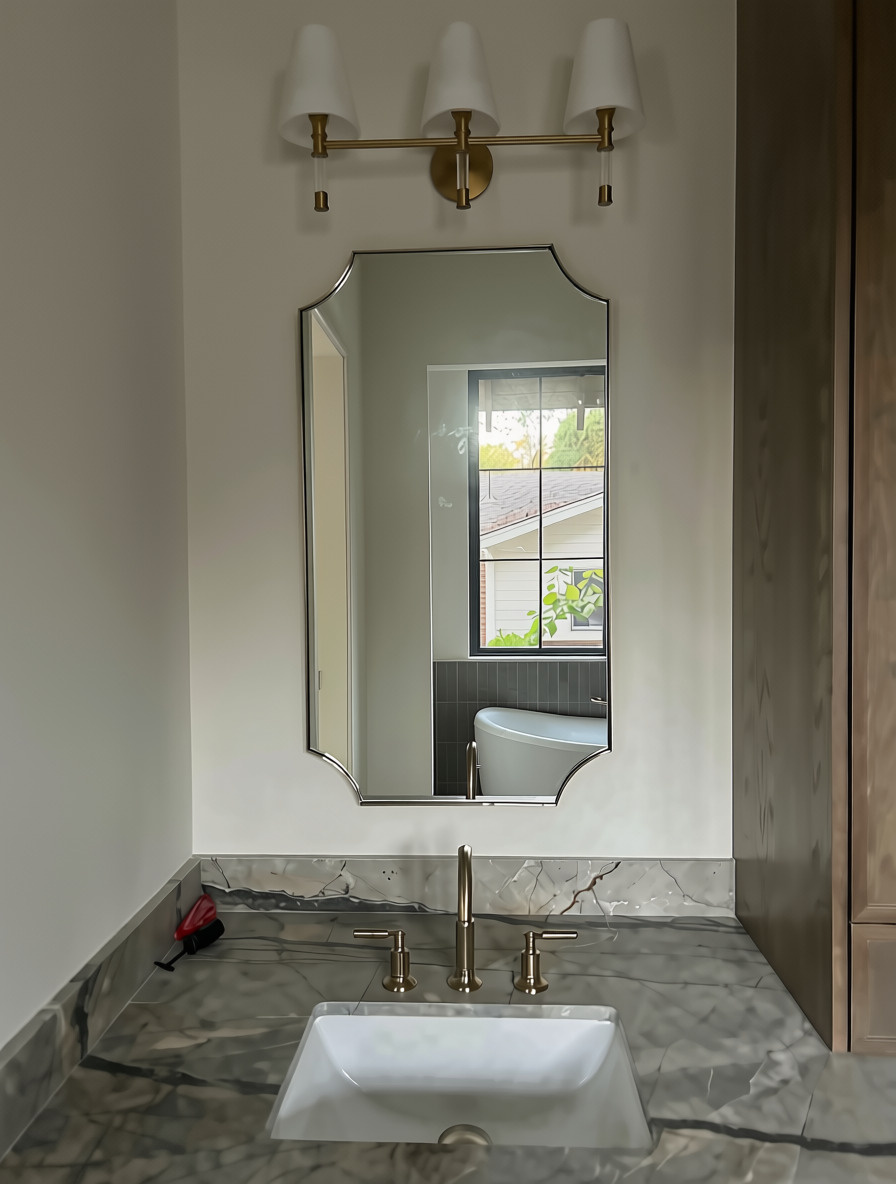 Second view of the arched-corner custom vanity mirror over a marble countertop in Austin, TX