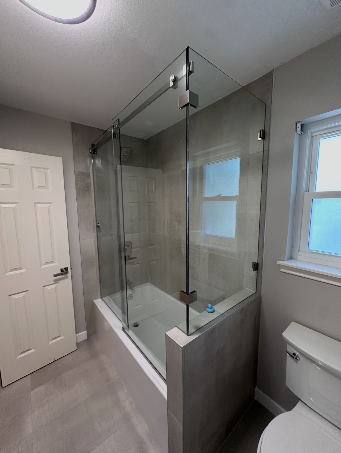 Brushed nickel top-roller hardware on a Serenity slider over a tub in Austin, TX