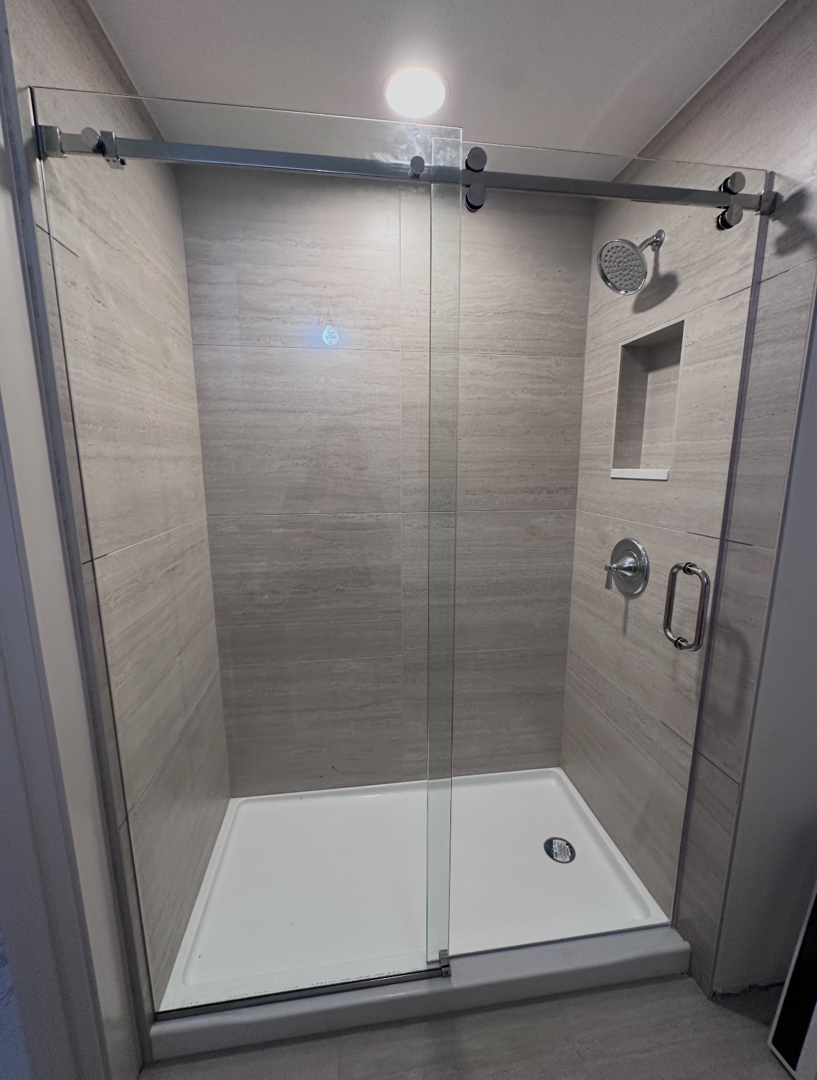 Frameless Serenity sliding shower door with polished chrome top rollers in Austin, TX