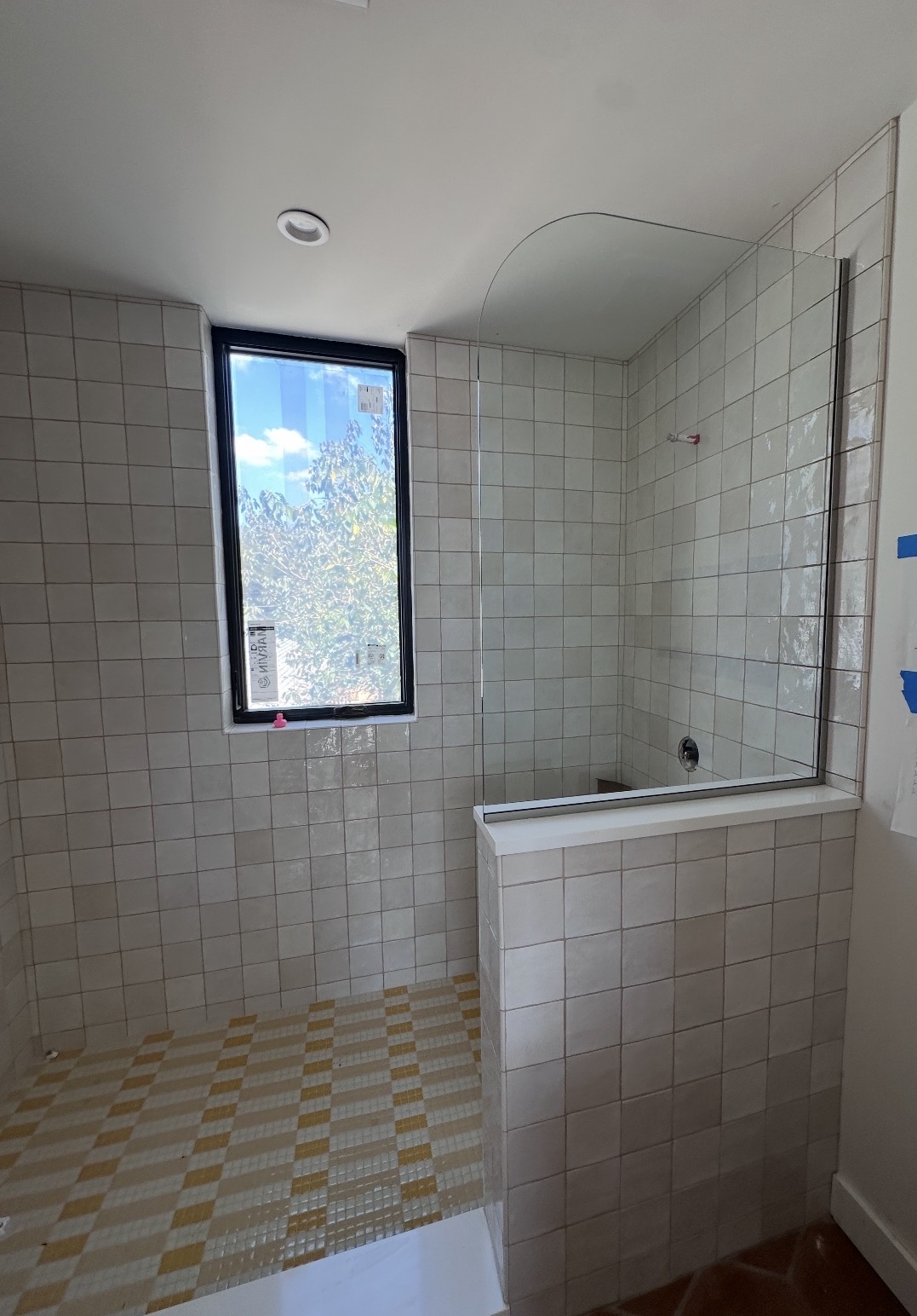 Frameless glass splash panel with a 12-inch radius corner on a tiled pony wall in Austin, TX