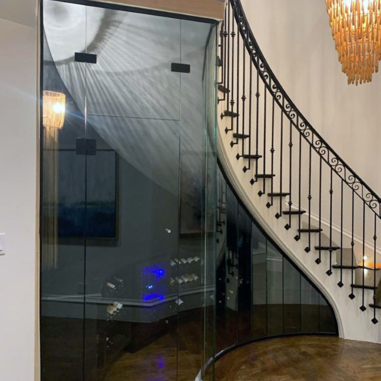 Curved glass wall wrapping a spiral wine cellar staircase