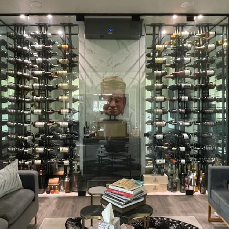Floor-to-ceiling glass wine cellar with lit wine racking