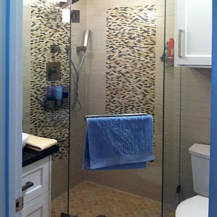 Frameless neo-angle glass shower enclosure in a corner of a bathroom