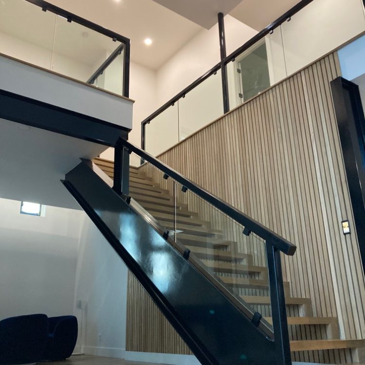 Close view of a glass guardrail panel above a staircase