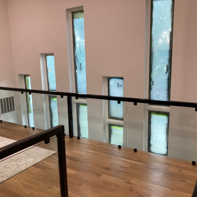 Glass railing panels running along an open two-story stairwell