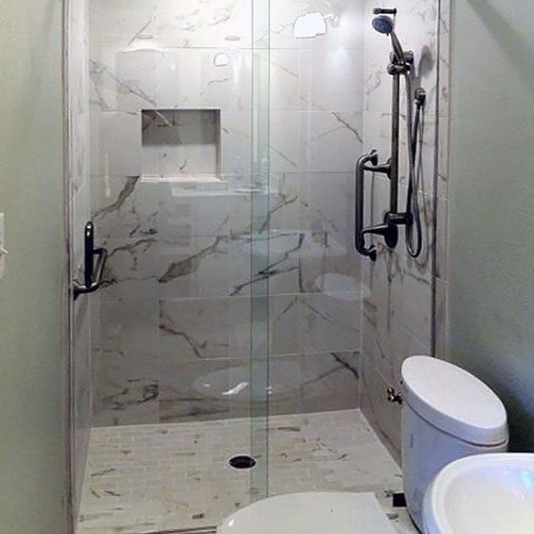 Sliding glass shower door with a stone tile surround