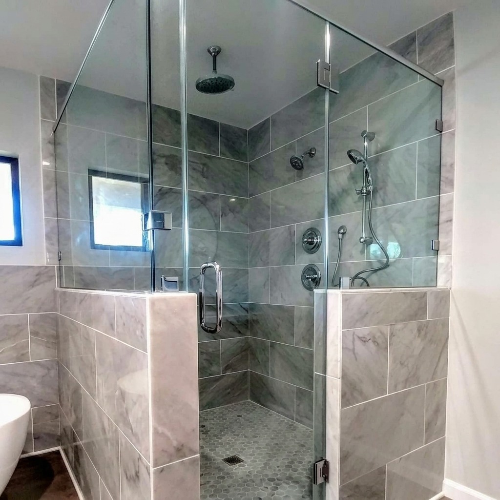 Frameless glass shower enclosure with marble tile installed by Shower Doors of Austin