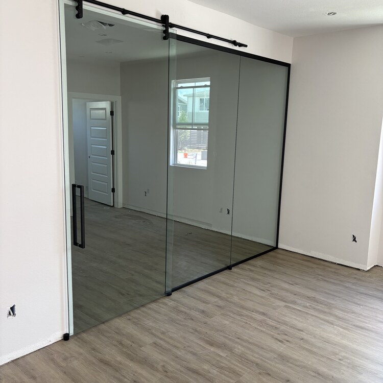 Sliding Glass Partition Door Sliding glass partition door on an exposed track in an interior opening