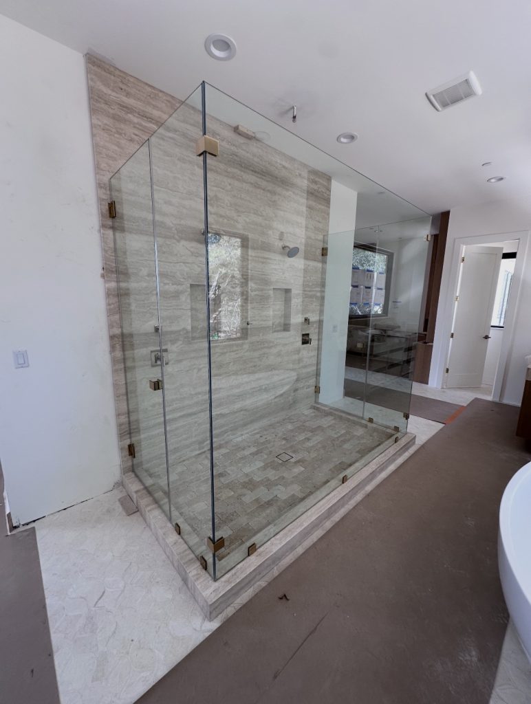 Frameless double 90-degree shower enclosure with dual entry doors and French gold hardware in Austin, TX